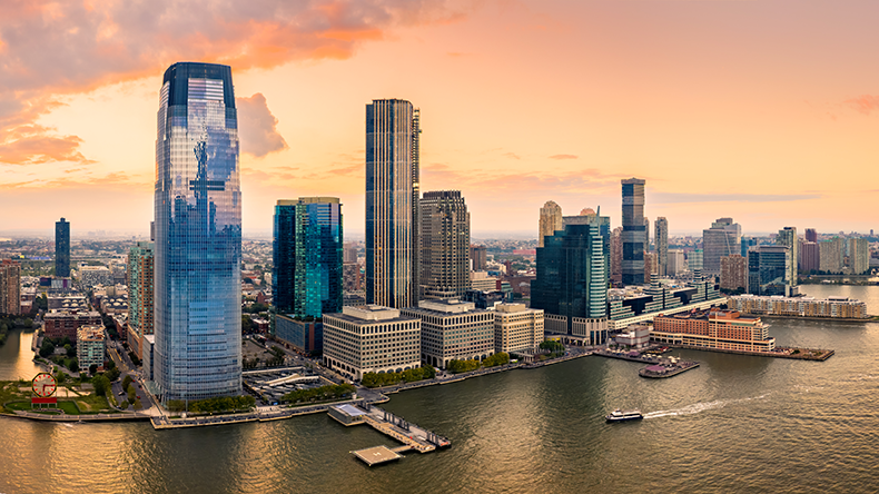 Aerial panorama of Jersey City skyline at sunset.