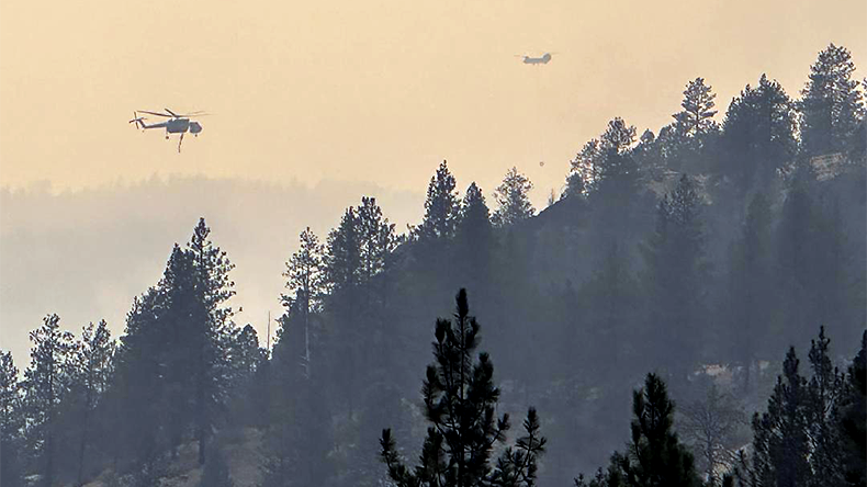 Spokane fires of summer 2026 in Washington state with helicopters battling forest flames