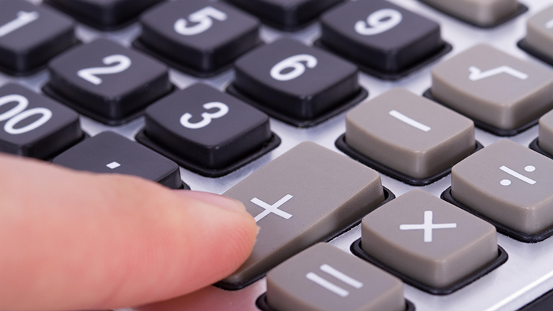 Finger pressing plus sign on a calculator