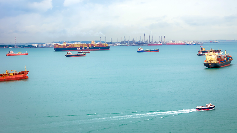 Cargo ships at Singapore Strait. Many boats floating in sea in one of the busiest ports in the world. Aerial drone view