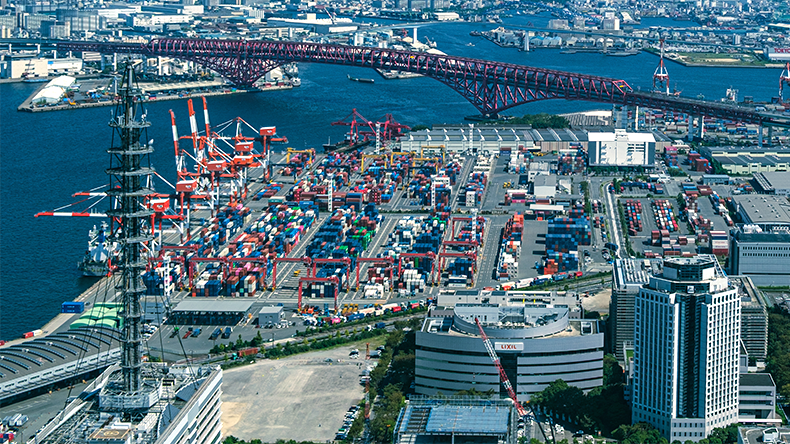 Aerial view of Osaka port container terminal with Red Arch bridge and city skyline