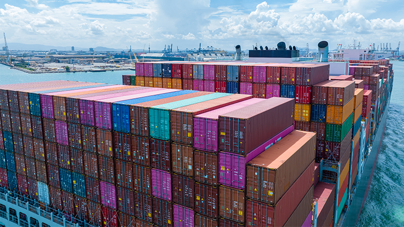 Stern of large containership entering port with a blue sky