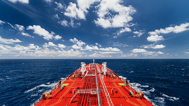 Large oil tanker sailing on open sea under blue sky